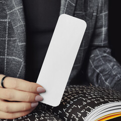 Woman holding a bookmark with rounded corners mockup