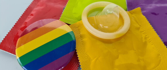 Condoms in packaging on rainbow icon