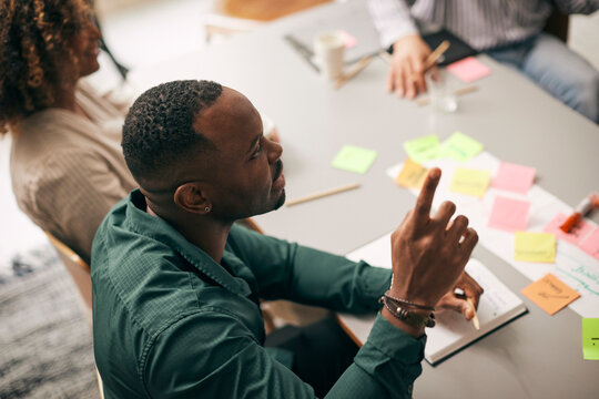 High angle view of businessman raising hand during meeting in creative office