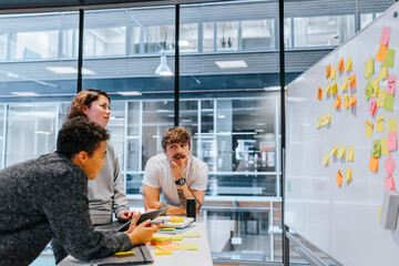 Male and female college students planning research project in modern classroom at university