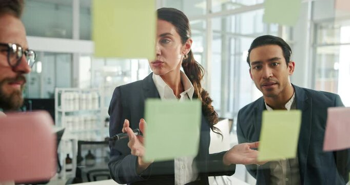 Woman, sticky note and writing on glass wall with team, planning and mind map for problem solving at startup. People, leader and group by board for review, talk and strategy for solution at company