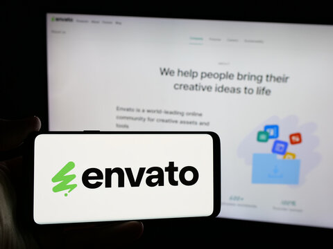 Stuttgart, Germany - 03-07-2025: Person holding smartphone with logo of Australian content platform company Envato on screen in front of business website. Focus on phone display.