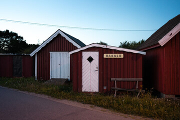 Red fishing cabins in Garpahamnen on Hassl&ouml; at dusk.