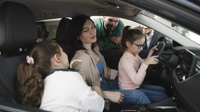 In a modern car dealership, a manager shows and advises a young family with children about buying or test driving a modern car. The concept of buying or leasing a new car.