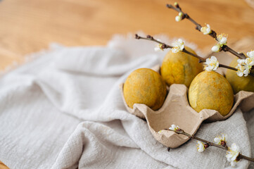 Olive-colored Easter eggs arranged on a rustic wooden table, creating a natural