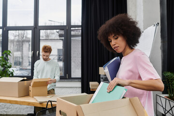 Obraz premium Organizing books and personal items during a modern move in a contemporary workspace