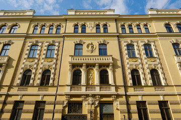 The facade of an old eclectic style building with decorative elements and arched windows on Vilandes street 5, Riga, Latvia.