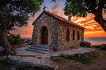 Fototapeta premium A charming sunset view from a hilltop church in Thassos, with warm orange hues blending into the deep blue sky