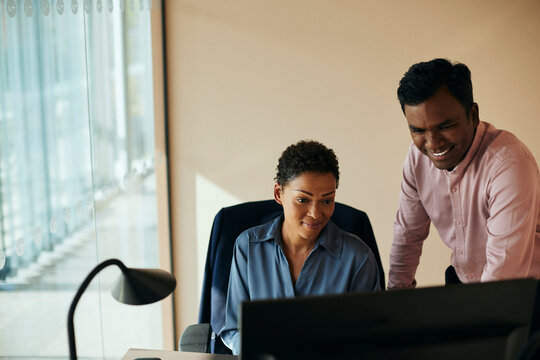 Aff&auml;rsman- och kvinna arbetar p&aring; dator i kontor