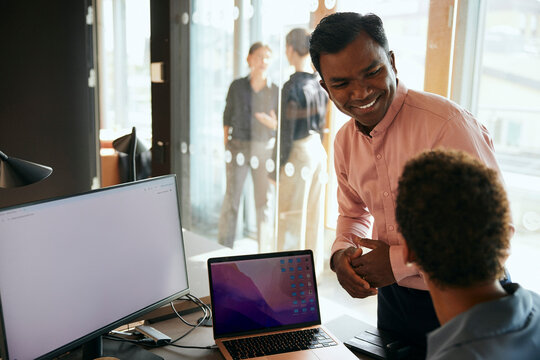 Glad aff&auml;rsman pratar med kvinnlig kollega p&aring; kontor