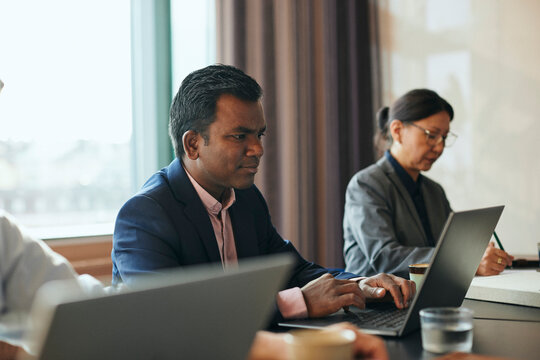 Manlig entrepren&ouml;r sitter i m&ouml;tesrum med kollegor