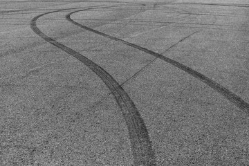 Car tire mark burnout on asphalt road race track, Abstract car tire mark from car on the asphalt road, Tire mark on race track texture and background, Black tire track skid mark on asphalt road. © Kalyakan