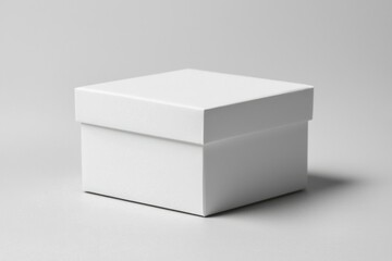 Fototapeta premium Square, solid white box with lid, casting soft shadows on a gray background. Minimal