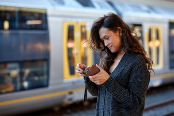 Young Asian woman checking mobile phone at train station