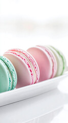 Pastel french macarons arranged on a white tray with soft colors and elegant styling. 