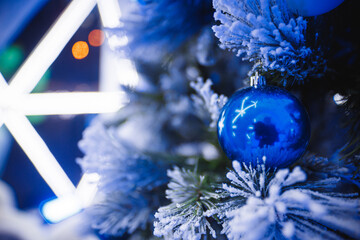 A detailed closeup view of a beautifully decorated Christmas tree featuring an array of stunning blue decorations that enhance its charm