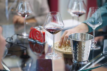 A beautiful glass table adorned with elegant wine glasses and an ice bucket filled with ice to keep the drinks perfectly chilled and refreshing