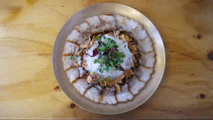 Top view of Korean bossam (boiled pork) beautifully plated on a brass dish