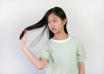 Fototapeta premium Portrait of Asian girl child using hand to comb hair on white background. Healthcare concept.