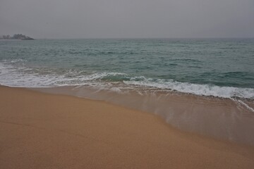 Gentle wave washing up on golden sand, capturing the peaceful rhythm of Korea’s east coast