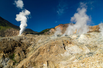 White steam calmly emitting from an active crater on a sunny day © Michael Tanujaya