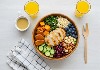 This image features a healthy salad bowl containing chicken breast, assorted vegetables and fruits,...
