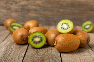 Kiwi on wooden background. Whole fruit and slices pieces of green kiwi on table. fresh ripe juicy...