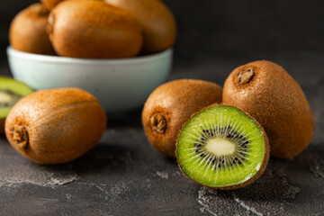 Kiwi on wooden background. Whole fruit and slices pieces of green kiwi on table. fresh ripe juicy...
