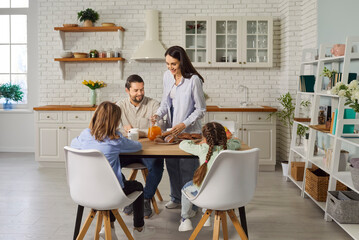 Happy family eating together, parents and kids in modern home kitchen enjoy healthy eating habits, cooking in modern place, culinary hobby fun, variety of nutritious foods, weekend at home activity