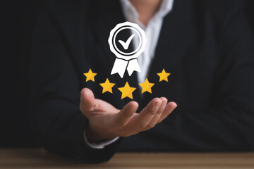 Businessman holding and showing the best quality assurance with golden five stars for guarantee...