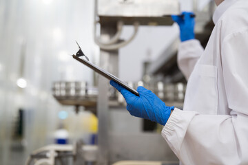 Canned fish factory, seafood manufacturing and processing. Food processing. Conveyor belt and workers. Hands of worker inspecting quality of seafood processing conveyor belts