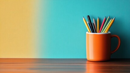 Bright and Colorful Desk Setup with Colored Pencils in an Orange Mug on a Wooden Surface Against Two-Tone Background