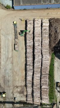 Vis&atilde;o a&eacute;rea vertical do estoque de toras de madeira e da produ&ccedil;&atilde;o industrial em uma f&aacute;brica de papel e celulose em opera&ccedil;&atilde;o no Brasil.