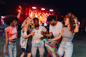 Friends enjoying drinks and dancing at music festival