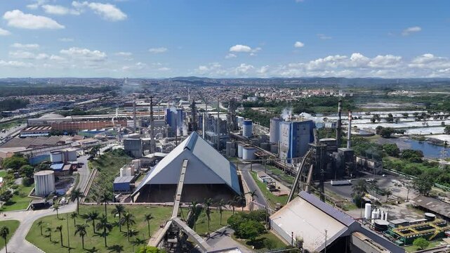 Vis&atilde;o a&eacute;rea do galp&atilde;o de estoque e dos equipamentos industriais em uma f&aacute;brica de papel, com destaque para a estrutura organizacional e maquin&aacute;rio em opera&ccedil;&atilde;o