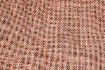 Fototapeta premium Burlap texture closeup with rough natural fiber surface in warm brown tones. Rustic burlap texture perfect for eco design, organic themes, craft backgrounds. Brown sacking texture. Grunge jute texture