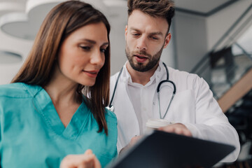 Doctors consulting medical information on tablet in hospital