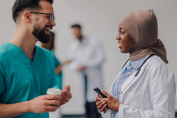 Doctors chatting during coffee break in hospital hallway
