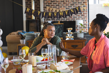 Adult family celebrating retirement with heartfelt conversation and delicious meal at home