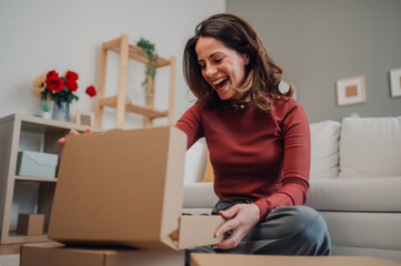 Happy woman opening cardboard box at home
