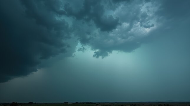 Vertical view of towering dark storm clouds against a stormy sky, distant horizon, moody natural disaster aesthetic