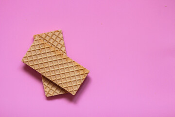 Waffles on a smooth pink background. perfect for illustrating a minimalist breakfast or dessert idea.