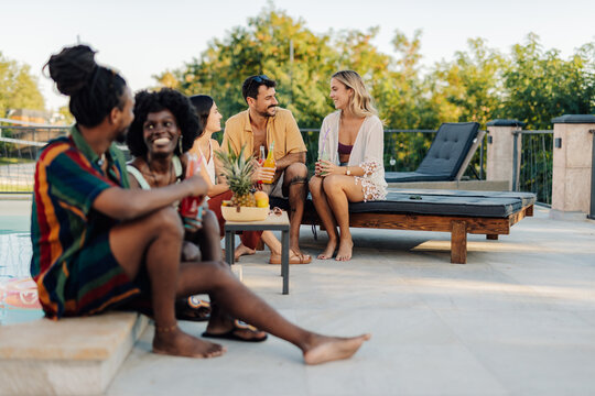 Friends enjoying drinks and conversation by the poolside