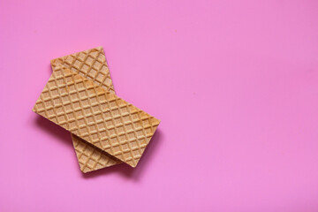 Waffles on a smooth pink background. perfect for illustrating a minimalist breakfast or dessert idea.