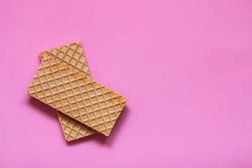 Waffles on a smooth pink background. perfect for illustrating a minimalist breakfast or dessert idea.