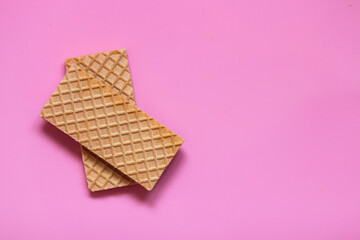 Waffles on a smooth pink background. perfect for illustrating a minimalist breakfast or dessert idea.
