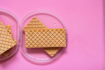 Waffles on a smooth pink background. perfect for illustrating a minimalist breakfast or dessert idea.