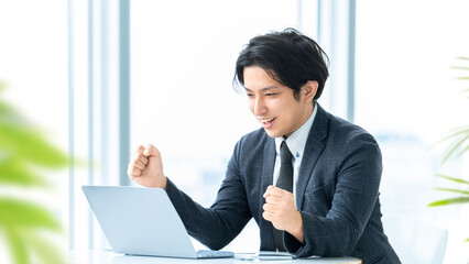 ガッツポーズをする笑顔の男性ビジネスマン