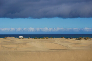 Sand dune with a sea beach at the background in Maspalomas, Gran Canaria