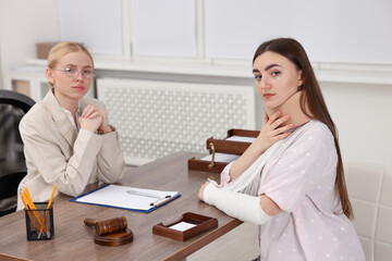 Injured woman and lawyer at table in office